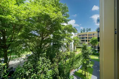 a window view of a street with trees and a building at Laguna Beachside Apartment 300 meters to the Bangtao Beach in Bang Tao Beach