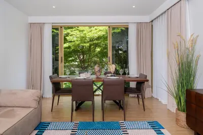 a dining room with a table and chairs and a couch at Laguna Beachside Apartment 300 meters to the Bangtao Beach in Bang Tao Beach