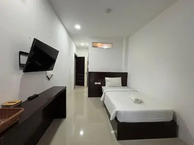 a small bedroom with a bed and a flat screen tv at Aqua Inn Ao Nang in Ao Nang Beach