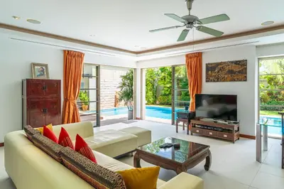 a living room with a couch and a tv at Exotic 3BR Villa Solandra with Tropical Pool and Private Rooftop Terrace in Bangtao in Bang Tao Beach