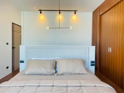 a bedroom with a large bed with a light above it at Modern ZEN Vibe 3BR Pool Villa Phuket in Ban Tha Khreng