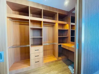 a walk in closet with wooden shelves and cabinets at Modern ZEN Vibe 3BR Pool Villa Phuket in Ban Tha Khreng