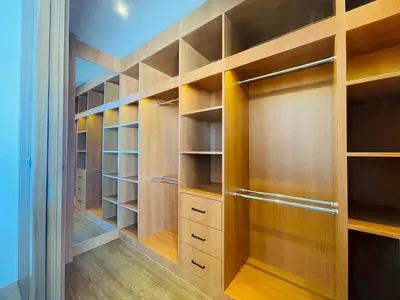 a walk in closet with wooden shelves and cabinets at Modern ZEN Vibe 3BR Pool Villa Phuket in Ban Tha Khreng