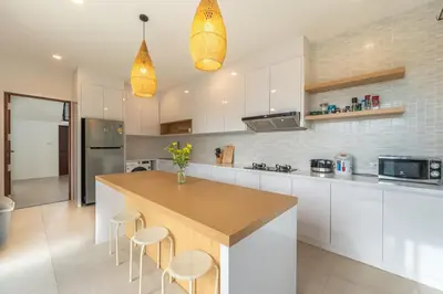 a kitchen with white cabinets and a island with stools at V212 One Of The Most Beautiful Villa In Phuket in Bang Tao Beach
