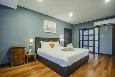 a bedroom with a large white bed and a wooden floor at Karon View 2 Bed 5 Minutes walk to Karon Beach 11 in Karon Beach