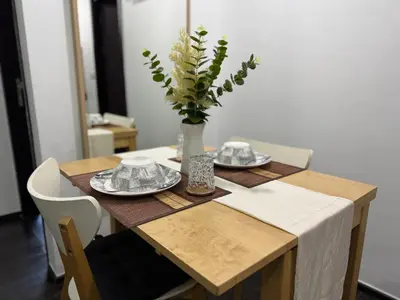 a dining room table with a vase of flowers on it at Room in Rawai in Rawai Beach