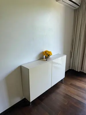 a white cabinet with a vase of flowers on it at Room in Rawai in Rawai Beach