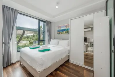 a bedroom with a white bed with a large window at C209 Surin Beachside Sun Escape & Infinity Pool in Surin Beach