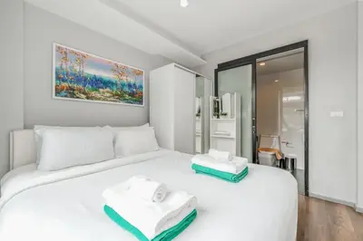 a white bed with two towels on top of it at C209 Surin Beachside Sun Escape & Infinity Pool in Surin Beach