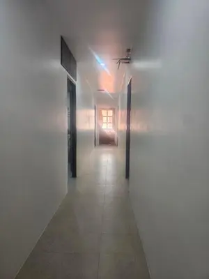 a hallway with white walls and a light at the end at Patong Central Budget Stay in Patong Beach