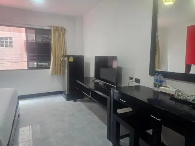 a room with a black desk and a television at Patong Central Budget Stay in Patong Beach