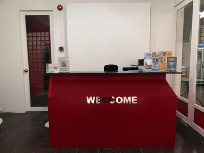 a red counter with the words we come on it at Patong Central Budget Stay in Patong Beach
