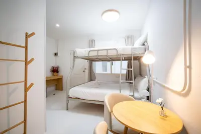 a small room with a table and bunk beds at ZJ House Phuket Town in Phuket Town