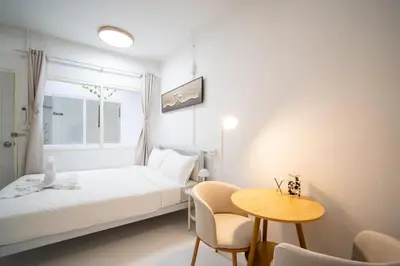 a bedroom with a bed and a table and chairs at ZJ House Phuket Town in Phuket Town