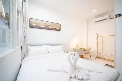 a bedroom with a white bed with a swan on it at ZJ House Phuket Town in Phuket Town
