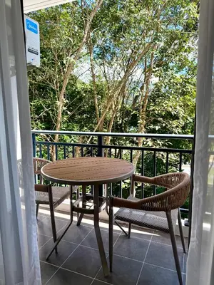 a wooden table and chairs on a balcony at Brand new apartment on Kamala in Kamala Beach