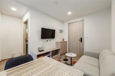 a living room with a couch and a table and a tv at C213 Fit Chill Condo with Pool and Gym in Kathu