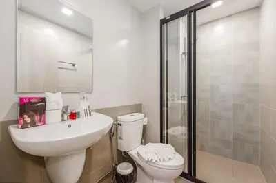a bathroom with a toilet and a sink and a shower at C213 Fit Chill Condo with Pool and Gym in Kathu
