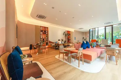 a living room with a couch and tables and chairs at C213 Fit Chill Condo with Pool and Gym in Kathu
