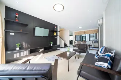a living room with a couch and a tv at Laguna Townhouse with private pool, Bang Tao Beach in Laguna Phuket