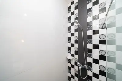 a bathroom with a shower with black and white tiles at Laguna Townhouse with private pool, Bang Tao Beach in Laguna Phuket