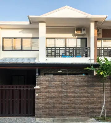 a house with a brick fence in front of it at Laguna Townhouse with private pool, Bang Tao Beach in Laguna Phuket
