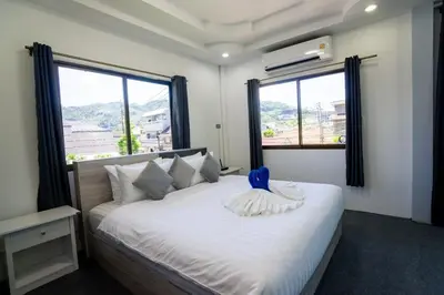 a bedroom with a white bed with a blue object on it at 3 Bed 3 Bath Villa 400m to Beach in Surin Beach