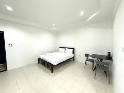 a bedroom with a bed and a desk in it at Patong Canal Villa 104 in Patong Beach