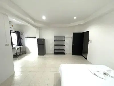 a white room with a refrigerator and a kitchen at Patong Canal Villa 104 in Patong Beach