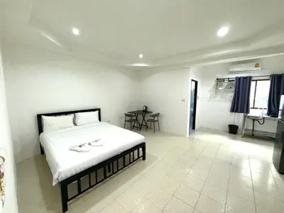 a bedroom with a bed and a table in it at Patong Canal Villa 104 in Patong Beach