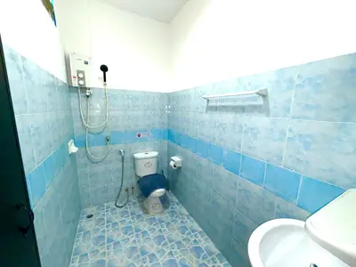 a blue tiled bathroom with a toilet and a shower at Patong Canal Villa 105 in Patong Beach