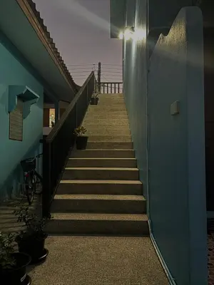 a stairway leading up to a building with a blue wall at GN House Bangtao in Ban Thalat Choeng Thale