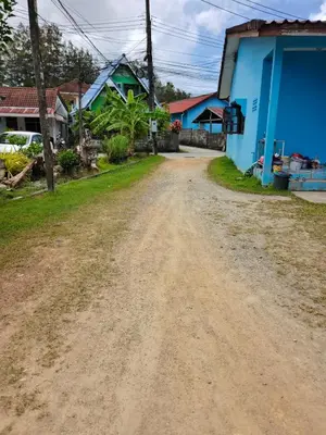 a dirt road in a village with houses at GN House Bangtao in Ban Thalat Choeng Thale