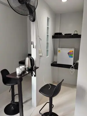 a small kitchen with a table and two chairs at GN House Bangtao in Ban Thalat Choeng Thale