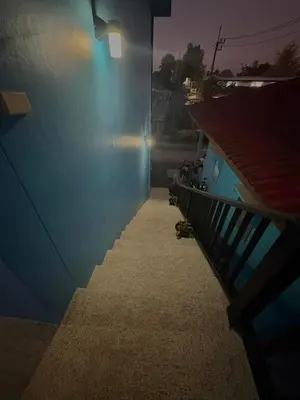 a stairway with a blue wall and a light at GN House Bangtao in Ban Thalat Choeng Thale