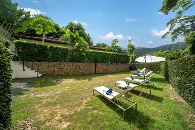 two lounge chairs and an umbrella in a yard at Oxavia Garden Oasis B3 in Nai Harn with Jaccuzzi in Rawai Beach