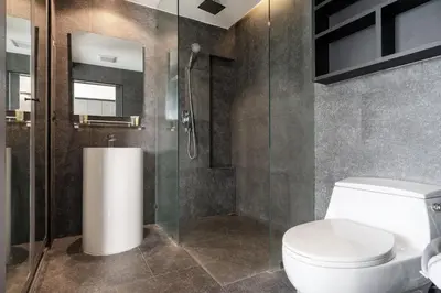 a bathroom with a toilet and a glass shower at Tropics Kamala Hill View Suite CTG L605, near Kamala Beach and Fantasea in Kamala Beach