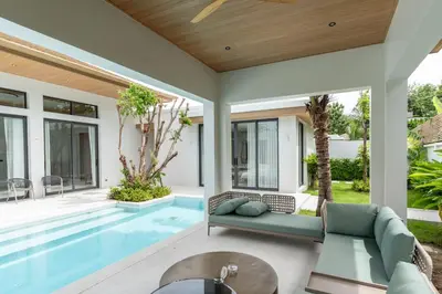an outdoor living room with a swimming pool and a house at Mouana Breeze Mai Khao 4-bedroom Pool Villa 9919 in Mai Khao Beach