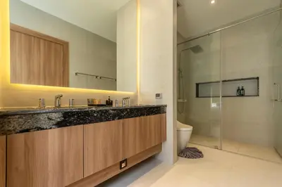 a bathroom with a sink and a toilet and a mirror at Mouana Breeze Mai Khao 4-bedroom Pool Villa 9919 in Mai Khao Beach