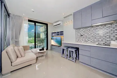 a living room with a couch and a kitchen at Tropics Kamala Apartment CTG L606, Several Pools, Gym & Rooftop in Kamala Beach