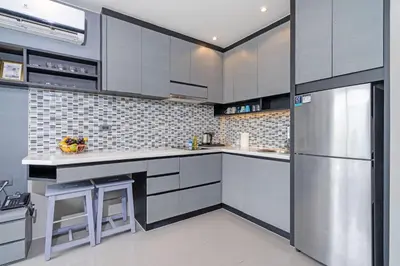 a kitchen with white cabinets and a stainless steel refrigerator at Enjoy Tropics Hill Views in Kamala Suite CTG L705, Top Facilities, near FantaSea & Café Del Mar Beach Club in Kamala Beach