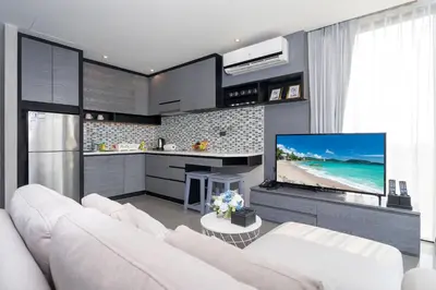 a living room with a white couch and a tv at Enjoy Tropics Hill Views in Kamala Suite CTG L705, Top Facilities, near FantaSea & Café Del Mar Beach Club in Kamala Beach