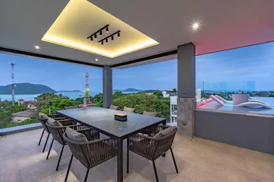 a dining room with a table and chairs at Luxury 6BR Seaview Statement Villa - Villa Legend in Ban Saiyuan (1)