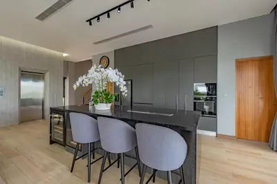 a kitchen with a black island with chairs and a counter at Luxury 6BR Seaview Statement Villa - Villa Legend in Ban Saiyuan (1)