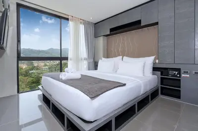 a bedroom with a large bed with a large window at Scenic Hill View Apartment CTG P609 in Tropics Kamala residence, Great Facilities, Close to Beach and Fantasea in Kamala Beach