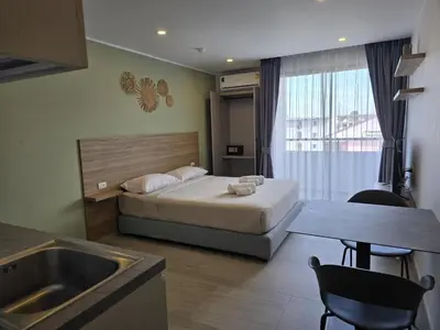 a bedroom with a bed and a table and a sink at Modern Studio Apt T3-526 in Chalong