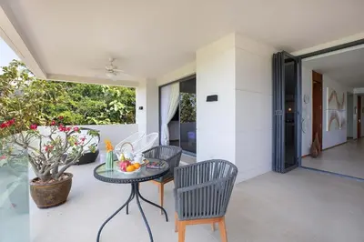 a patio with a table and chairs and a glass table at Stunning Seaview Escape - Modern and Elegant in Kata Beach