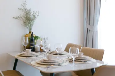 a white table with plates and wine glasses on it at Relax Nai Yang beach pool Villas in Nai Yang Beach
