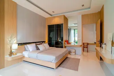 a bedroom with a large bed and a desk at Relax Nai Yang beach pool Villas in Nai Yang Beach