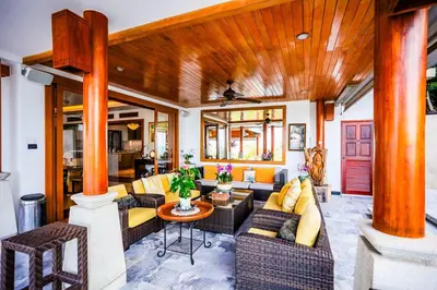 a living room filled with furniture and a wooden ceiling at Villa Talay in Surin Beach